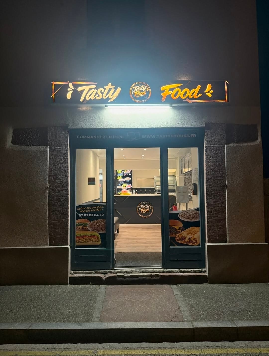 Devanture du snack Tasty Food à Guebwiller, illuminée la nuit
